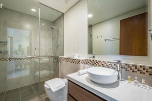 A modern bathroom with a glass-enclosed shower, a large white sink, and a mirror above the vanity. - Enticing 2BR Apartment in Reva Residences, Business Bay by Deluxe Holiday Homes (Dubai)