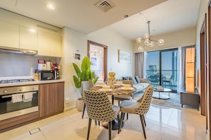 A modern kitchen with a dining area, featuring a large window with a view of the cityscape.