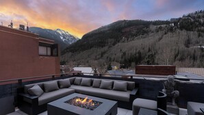 A rooftop patio with a fire pit, outdoor seating, and a view of mountains. - New Penthouse, Center of Town, Sauna, Deck, Fireplace, Views, Parking, Ski Room (Telluride)