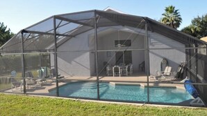 Une piscine couverte avec un espace patio et du mobilier d’extérieur.