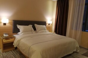 A hotel room with a large bed, two bedside lamps, a bedside phone, and a window with curtains. - yixijiudian (Baise)