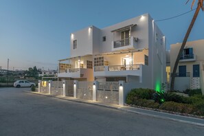 A modern two-story residential building with balconies, a gated entrance, and a driveway. - Orama Milos (Milos)
