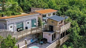 Una proprietà residenziale su più livelli, con piscina sul tetto, area salotto esterna e un balcone.