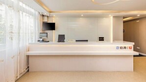 A modern reception desk with a flat-screen TV, a digital display, and a nameplate. - 7 Days Premium Hotel (Guangzhou International Finance City Tangdong Metro Station) (Guangzhou)