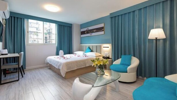 A modern hotel room with a bed, a desk, a chair, and a lamp. - 7 Days Premium Hotel (Guangzhou International Finance City Tangdong Metro Station) (Guangzhou)