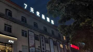 Un edificio con letreros de un restaurante KFC y una tienda de productos de 7 días.