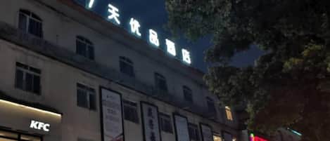 A building with signage for a KFC restaurant and a 7-day product store.