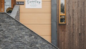 Ein Gebäudeeingang mit einem Schild für 'Treetop SPA HANGOUT & HOTEL'.