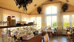 A breakfast buffet area with glass containers, a coffee station, and a table set for two. - Hotel Nordwind Lohme (Lohme)