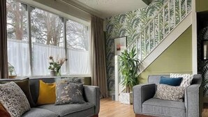 En stue med sofa, lænestol og et tæppe.