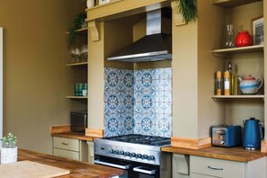 A kitchen with a stove, oven, and tiled backsplash.