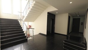 A modern interior with a staircase, a door, and a hallway. - hotel noida express (Noida)