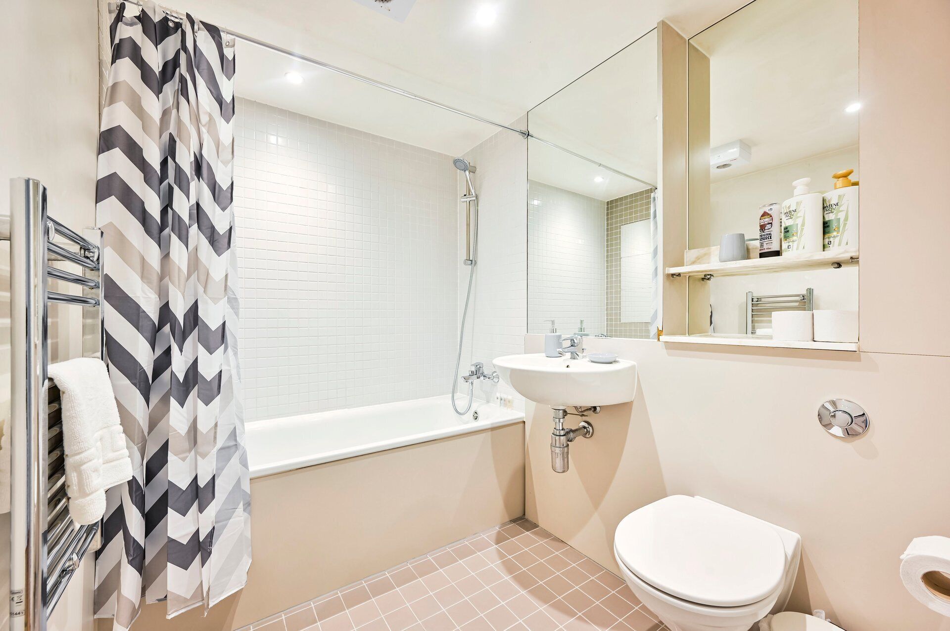 Un baño con ducha, lavabo, inodoro y espejo.
