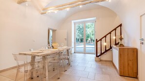 A dining area with a wooden table, clear chairs, and a wooden cabinet. - Palazzo Biscilia in Bisceglie (Bisceglie)