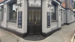 The exterior of the Sarah Hotel with a reception sign, lounge sign, and a black door. - Sarah Hotel (Harwich)