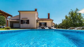 A swimming pool with a house in the background. - Pool House Robertino (Tar-Vabriga)