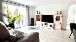 A modern living room with a sofa, a coffee table, a TV, and a cabinet.