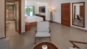 Une chambre d’hôtel moderne équipée d’un lit, d’un bureau, d’une chaise, d’une télévision et d’un grand miroir.