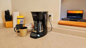 A kitchen counter with a coffee maker, a mug, a bottle of dish soap, and a roll of paper towels. - Spacious & Convenient 1BR unit-20min to Boston (Melrose)