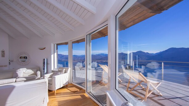A spacious room with a large sliding glass door leading to a balcony with a mountain view. - The Perfect View Loft (Premeno)