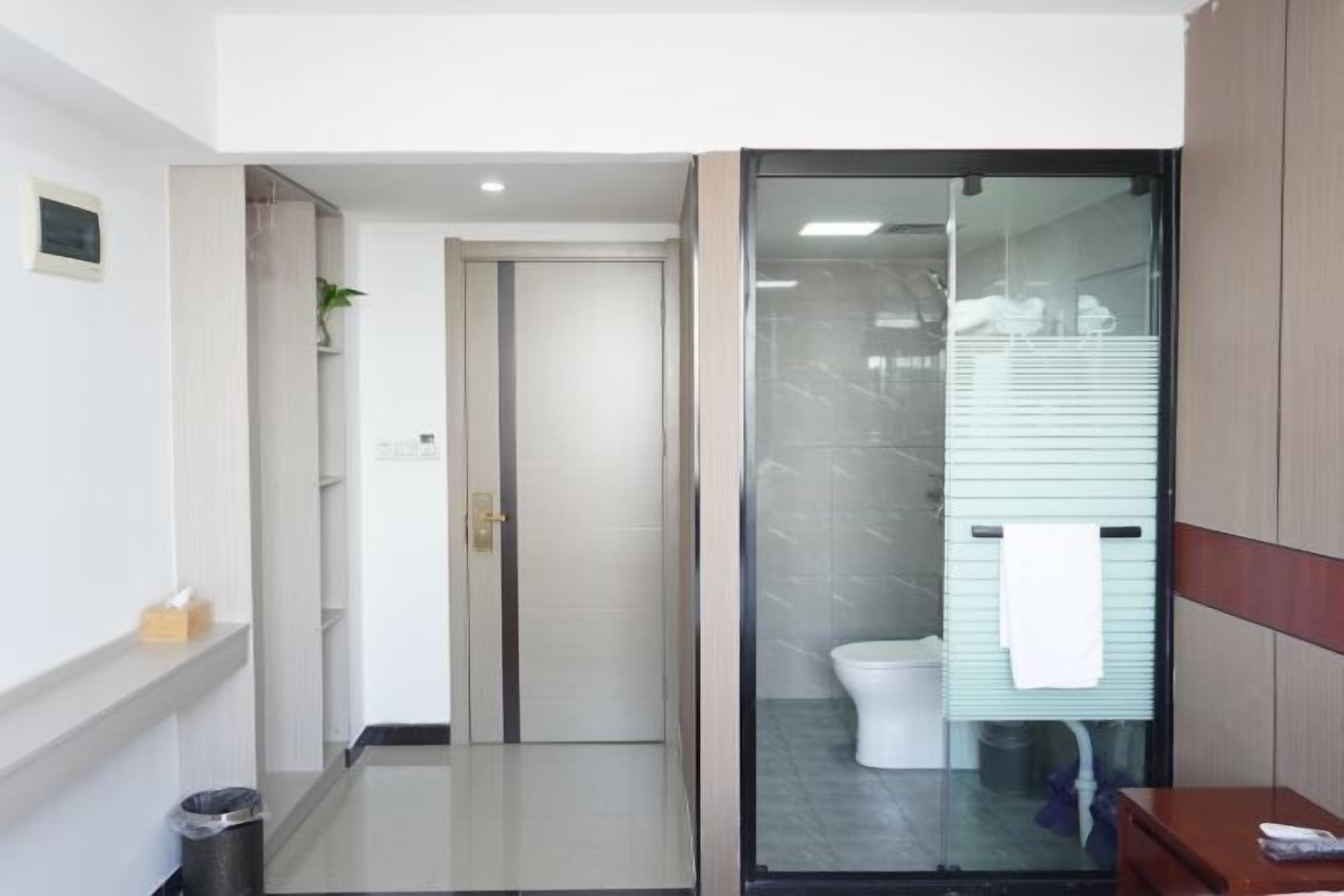 A modern bathroom with a glass shower enclosure, a toilet, and a sink.