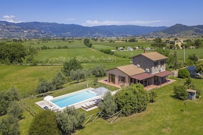 A house with a swimming pool, surrounded by lush greenery and mountains in the background. - Villa San Lorenzo in Cortona (Cortona)