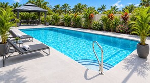 A swimming pool with lounge chairs and a gazebo.
