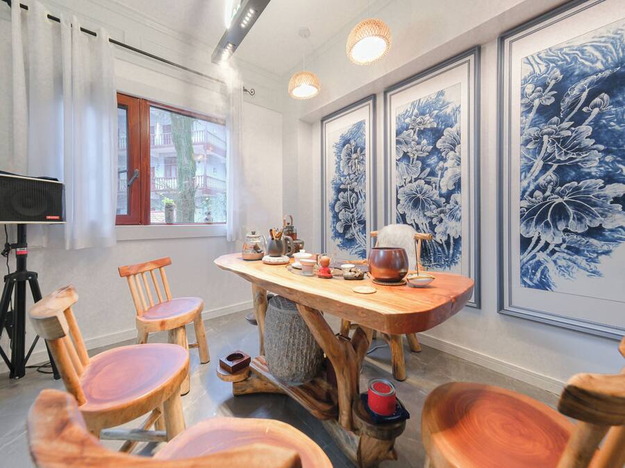 A dining area with a wooden table, chairs, and artwork on the walls.