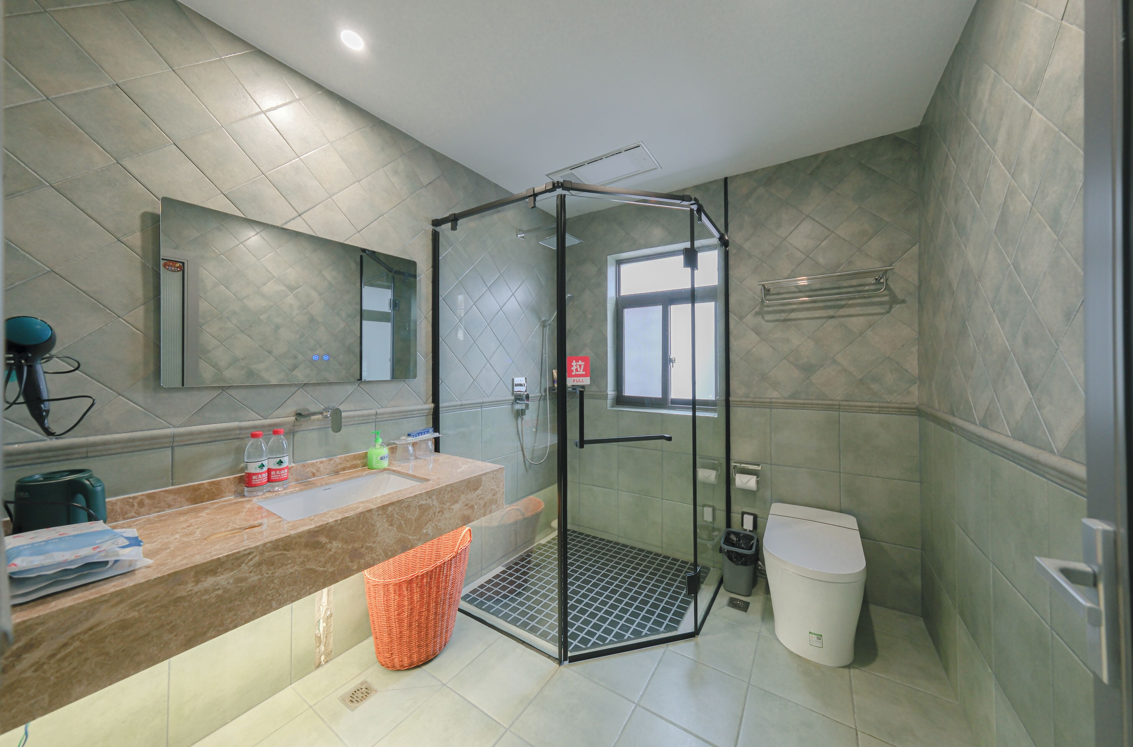 A modern bathroom with a glass-enclosed shower, a marble sink, and a toilet.