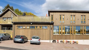 A modern building with a wooden facade, large windows, and a covered outdoor seating area. - 4 Star Holiday Home in Hisings Backa (Hisings Backa)