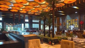 A lobby with a reception desk, seating area, and decorative ceiling lights.