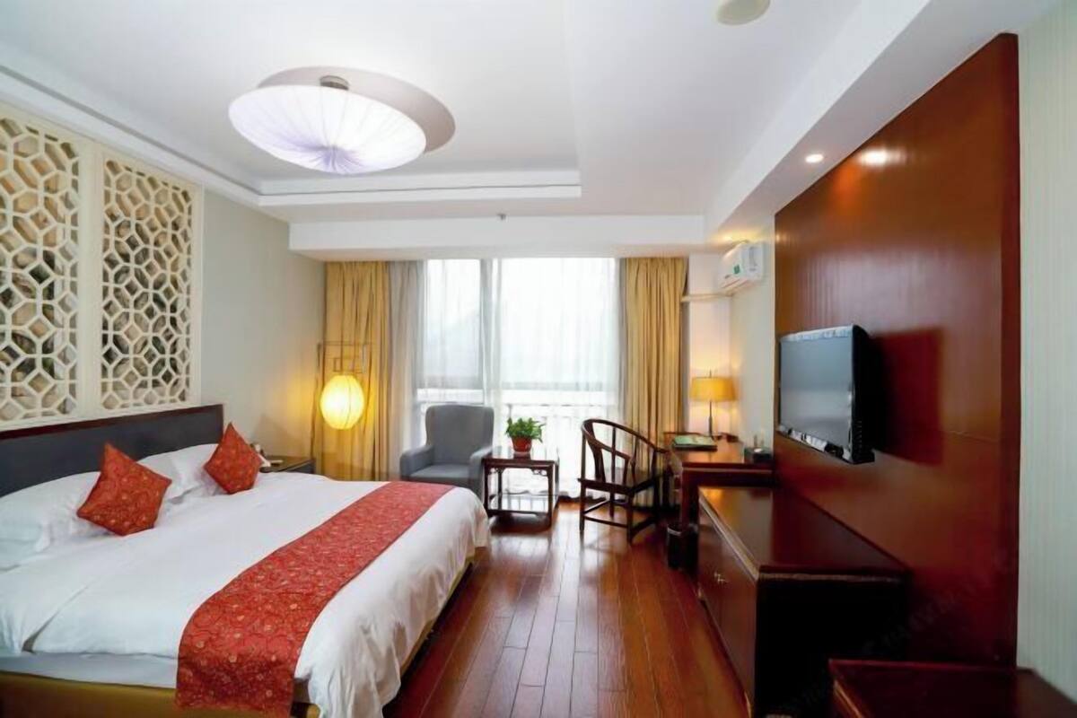 Una habitació d'hotel amb un llit, una televisió, una taula i una cadira.
