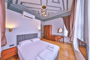 A hotel room with a large bed, a desk, a wardrobe, and a mirror. - Va Mansion Kadıköy (Istanbul)