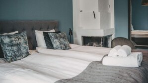 A bedroom with a bed, pillows, a bedside table, a lamp, a mirror, and a fireplace. - 4 Star Holiday Home in Hisings Backa (Hisings Backa)