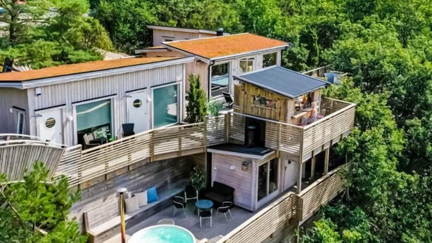 A multi-level wooden house with a hot tub, outdoor seating, and a balcony. - 4 Star Holiday Home in Hisings Backa (Hisings Backa)