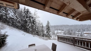 A wooden deck with a table and chairs, overlooking a snowy landscape with trees and a distant view. - Chalet, ski lifts base, sauna, terrace, balcony, fireplace or stove, tv, 160m², Villard de Lans (Corrençon-en-Vercors)