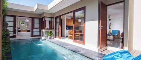 Una casa moderna con piscina, comedor y cocina.