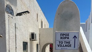 A signpost with a directional arrow pointing upwards, indicating the way to the village. - Casa filareti (Ios)