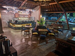 Een restaurant met een bar, zitplaatsen en uitzicht op het buitengebied.