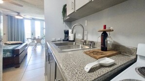 Una cocina moderna con encimeras de granito, electrodomésticos de acero inoxidable y un comedor con mesa y sillas.