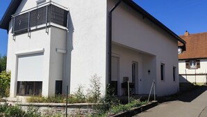 Ein modernes, zweistöckiges Gebäude mit Garage, Balkon und Auffahrt.