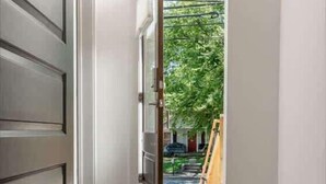 Una escalera conduce a un espacio exterior con vistas a zonas verdes y una estructura de madera.