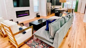 Una sala de estar moderna con un sofá gris, una mesa de centro y una chimenea.