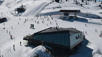 A ski resort with a modern building, ski lifts, and a snow-covered landscape.