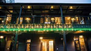 A two-story building with a balcony, wooden doors, and string lights. - Xiyuan Villa (Deqing)