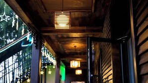 A corridor with wooden walls, hanging star decorations, and a series of lights along the ceiling. - Xiyuan Villa (Deqing)