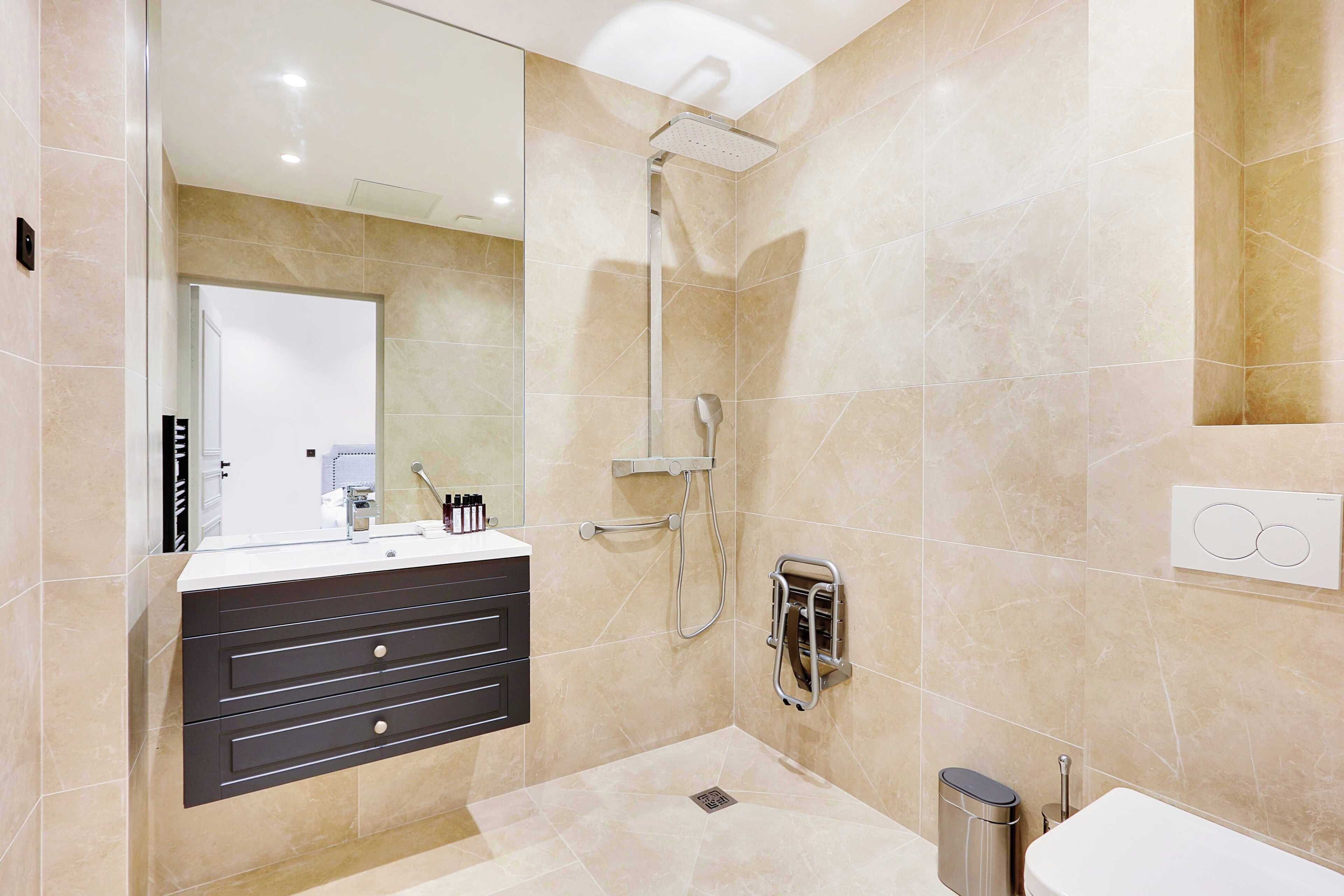 A modern bathroom with a shower, a vanity with drawers, a mirror, and a toilet.