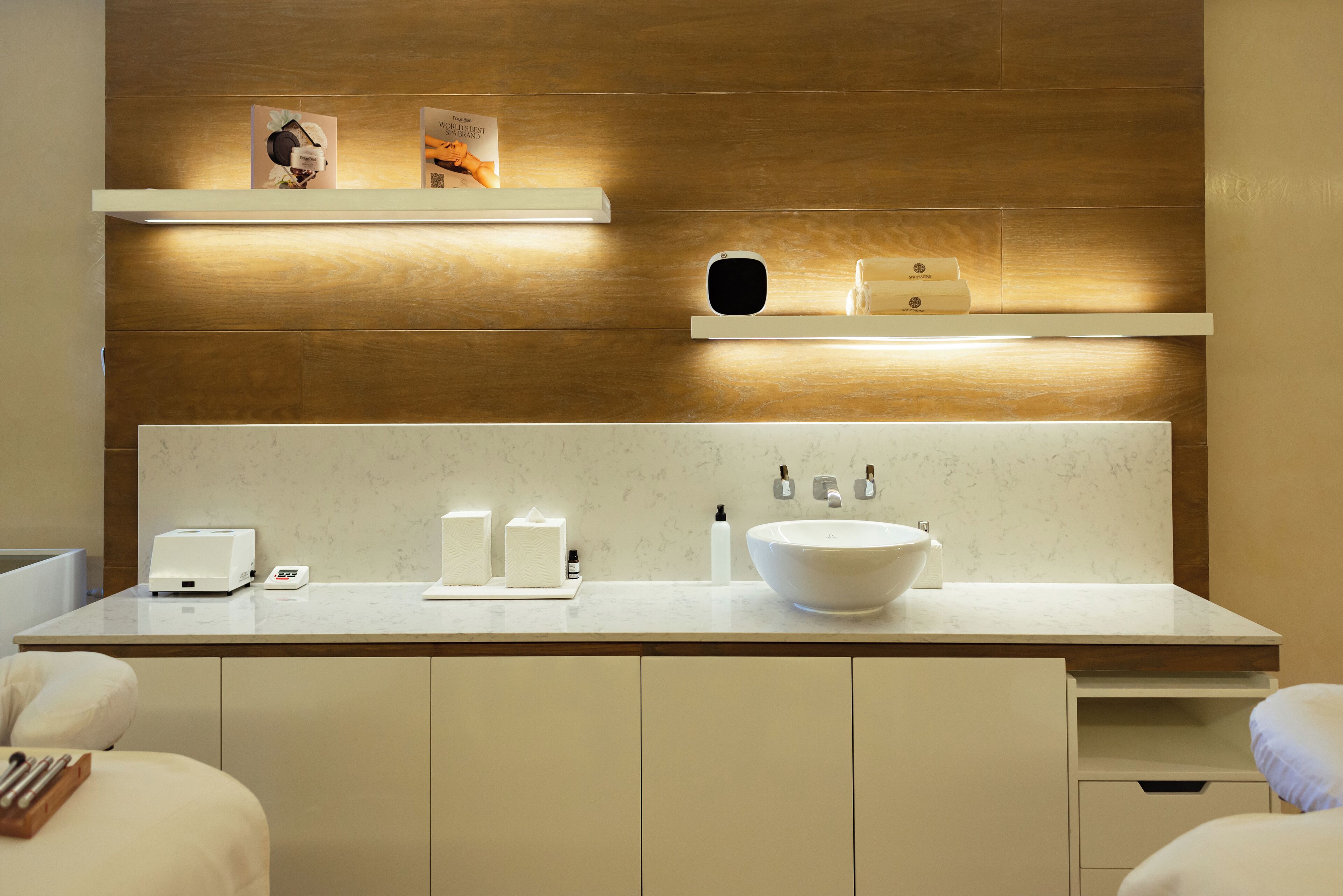 A modern bathroom with a large white sink, a mirror, and a countertop with toiletries.