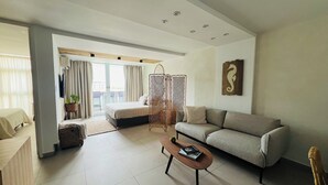 A spacious living area with a sofa, a coffee table, a bed, and a balcony with a view. - Seaside getaway in Isla Verde beach for 4 guest. Book now! (Carolina)