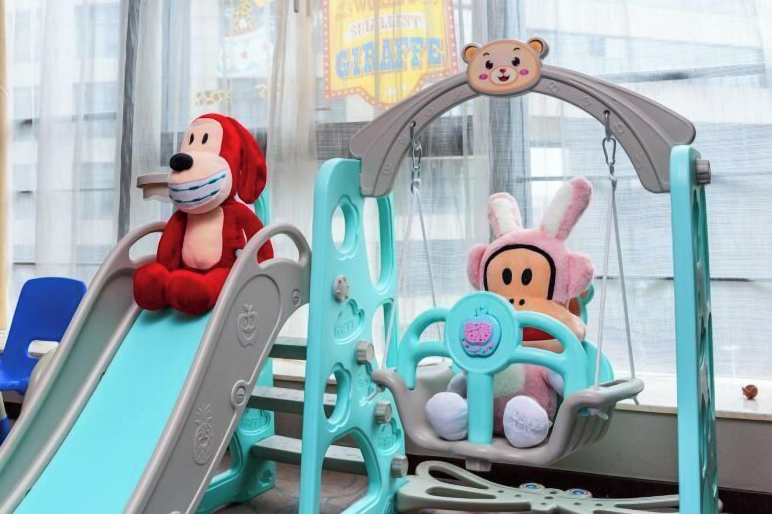 A children's play area with a slide and a hanging seat.